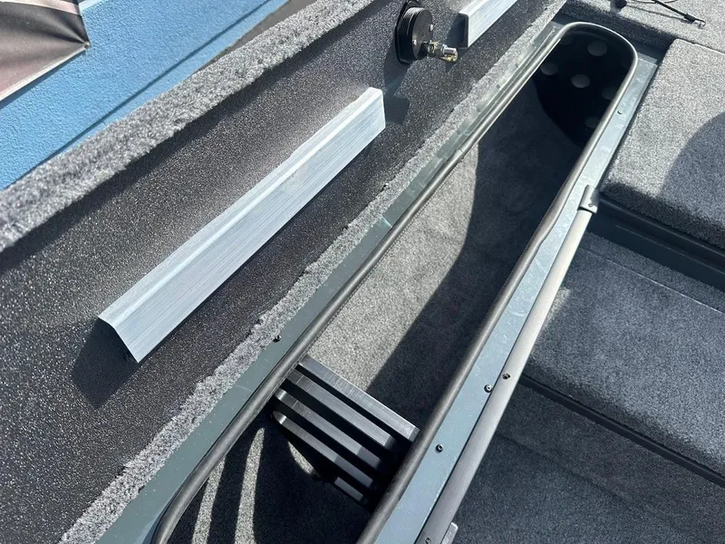 Slide: The Image of 2025 Ranger RT178 boat storage compartment with carpeted interior and secure latch. - 26