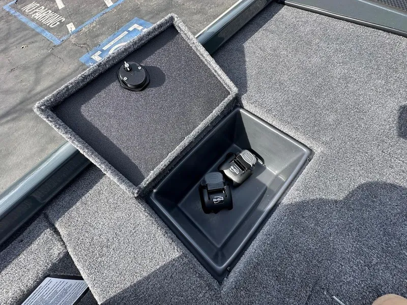 Slide: The Image of 2025 Ranger RT178 boat storage compartment with carpeted lid and accessories inside. - 31