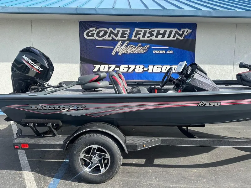 Slide: The Image of 2025 Ranger RT178 boat with Mercury engine, parked near "Gone Fishin'" sign. - 7