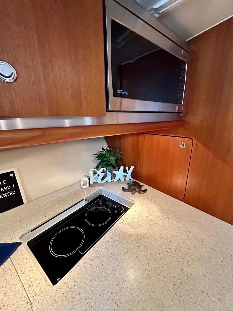 Slide: The Image of 2007 TIARA 36 OPEN kitchen with microwave, stovetop, and "Relax" decor. - 16