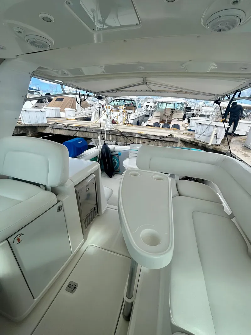 Slide: The Image of 2007 Open TIARA 36 yacht interior with white seating and table, docked at marina. - 3