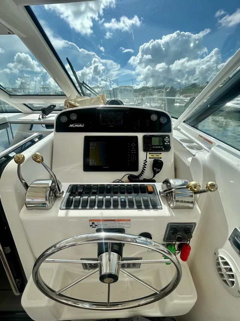 Slide: The Image of Helm of 2007 Open TIARA 36, featuring navigation controls and steering wheel under a sunny sky. - 7