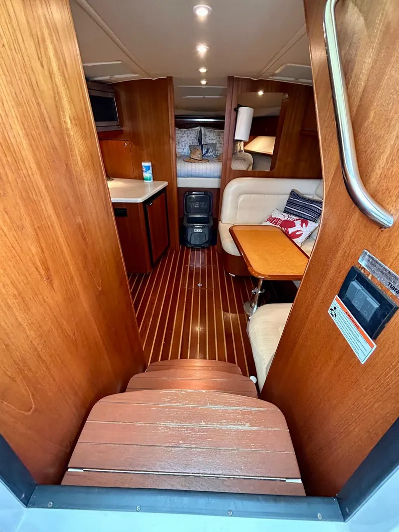 Slide: The Image of 2007 TIARA 36 OPEN yacht interior with wooden flooring, seating area, and kitchenette. - 8