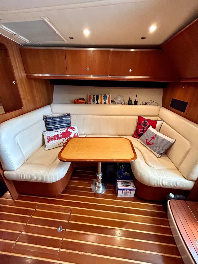 Slide: The Image of 2007 TIARA 36 OPEN yacht interior with wooden flooring, cushioned seating, and decorative pillows. - 9