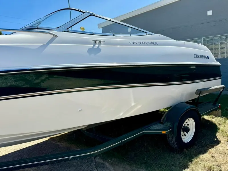 Slide: The Image of 1998 Four Winns Sundowner 205 boat on trailer, white and black exterior. - 5