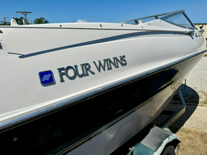 Slide: The Image of 1998 Four Winns Sundowner 205 boat, white exterior, parked on a trailer, side view. - 7