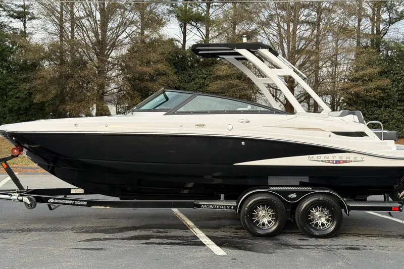 Slide: The Image of 2025 Monterey M4 boat on trailer, parked outdoors with trees in background. - 25