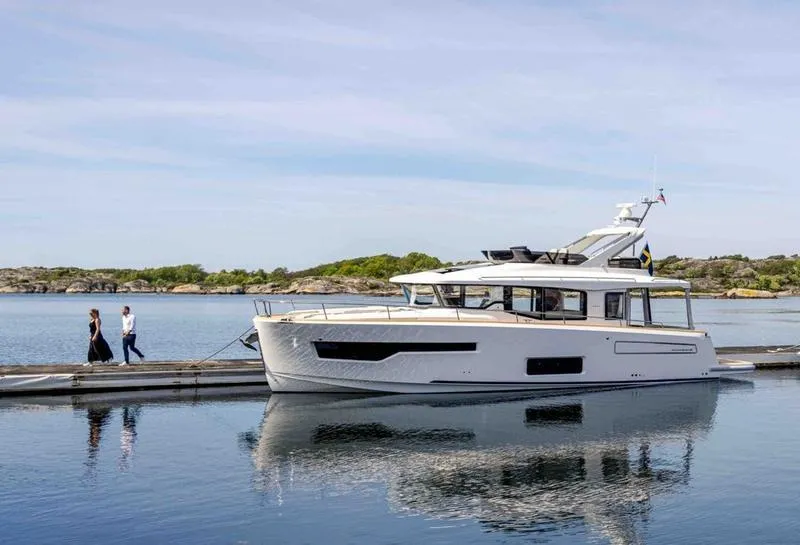 The Image of Nimbus 495 Flybridge 2025 yacht docked on calm water with scenic background. - 0