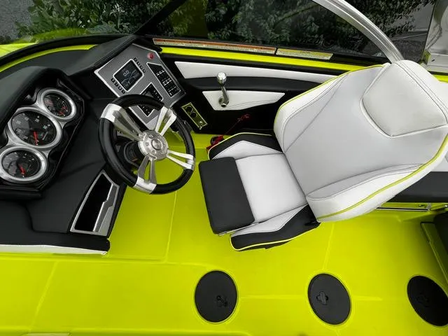 Slide: The Image of 2018 MasterCraft XT20 boat interior with lime green flooring and modern dashboard. - 17