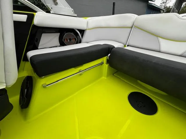 Slide: The Image of 2018 MasterCraft XT20 boat interior with lime green flooring and cushioned seating. - 19