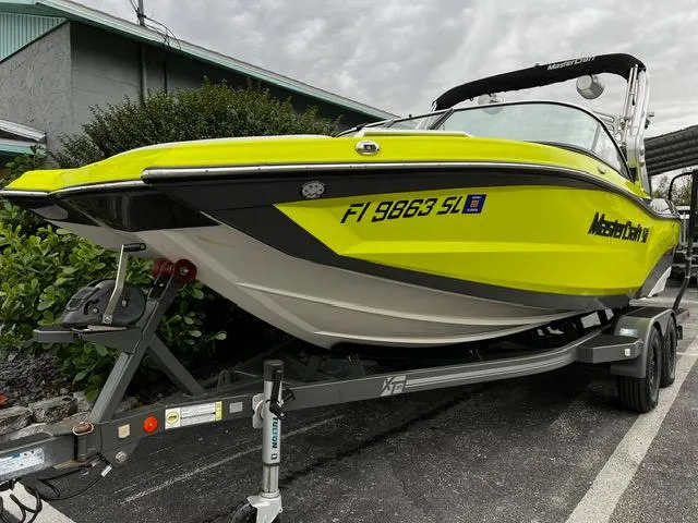 Slide: The Image of 2018 MasterCraft XT20 boat on trailer, vibrant yellow hull, parked outdoors. - 3