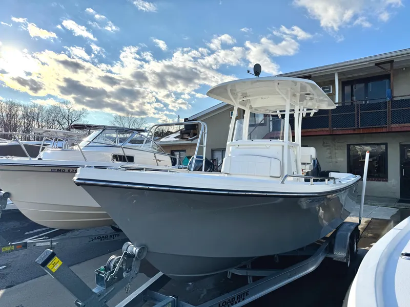 Slide: The Image of 2020 Parker 2300 Special Edition boat on trailer, parked outdoors under a partly cloudy sky. - 1