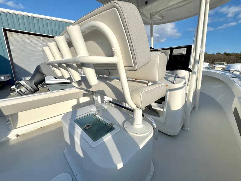 Slide: The Image of 2020 Parker 2300 Special Edition boat with cushioned seating and storage, docked outdoors. - 13