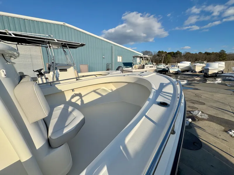Slide: The Image of 2020 Parker 2300 Special Edition boat docked near a blue warehouse under a clear sky. - 19
