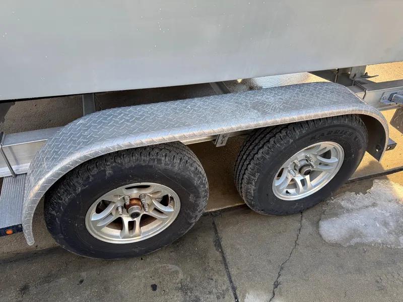 Slide: The Image of Trailer wheels of a 2020 Parker 2300 Special Edition boat on pavement. - 22