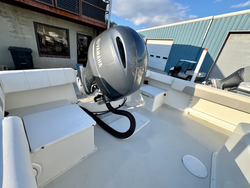 Slide: The Image of 2020 Parker 2300 Special Edition boat with Yamaha outboard motor, docked near industrial buildings. - 9