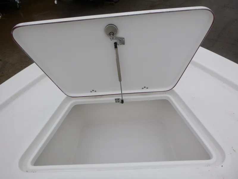 Slide: The Image of 2025 Sea Pro 250 Bay boat storage compartment with open lid, showcasing interior details. - 18