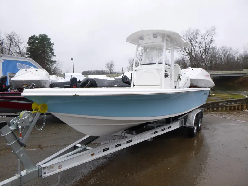 Slide: The Image of 2025 Sea Pro 250 Bay boat on trailer, parked outdoors under blue sky. - 2