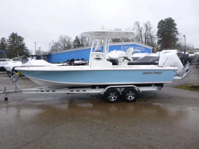 Slide: The Image of 2025 Sea Pro 250 Bay boat on trailer, parked outdoors under blue sky. - 3