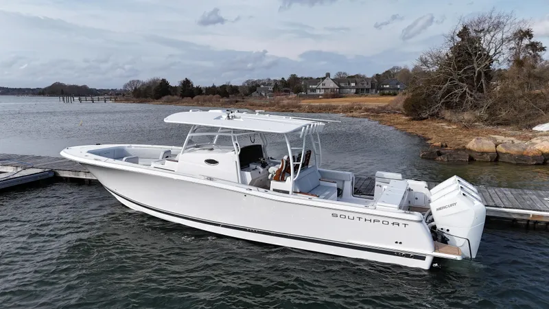 The Image of 2025 Southport 38 FE boat on calm water with lush green shoreline. - 0