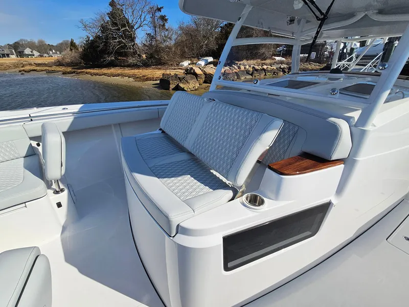Slide: The Image of 2025 Southport 38 FE boat with sleek design and comfortable seating on calm water. - 24