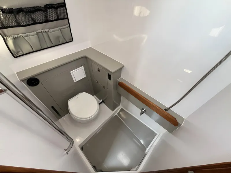 Slide: The Image of 2025 Southport 38 FE boat with open storage compartment and cushioned seating. - 34