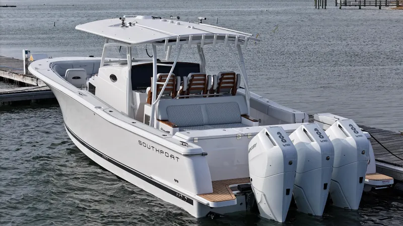 Slide: The Image of 2025 Southport 38 FE boat interior with helm, wooden seats, and water view. - 42