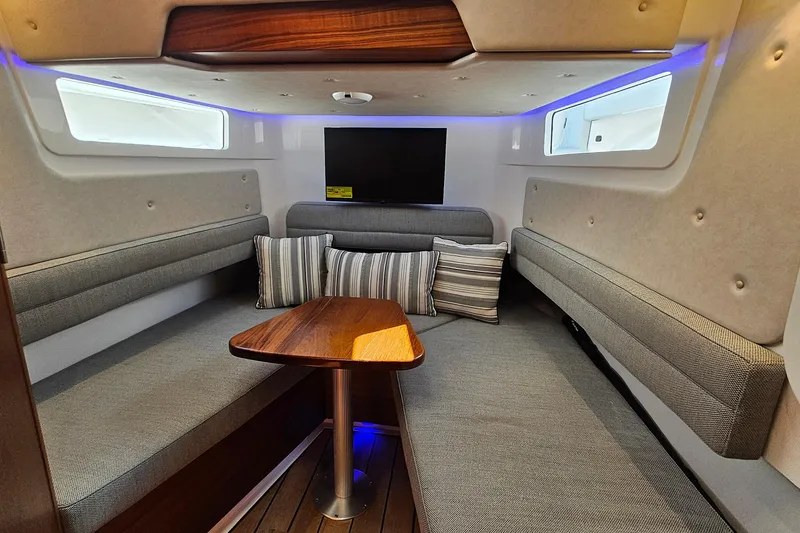 Slide: The Image of 2025 Southport 38 FE cabin interior with cozy seating and wooden table. - 64