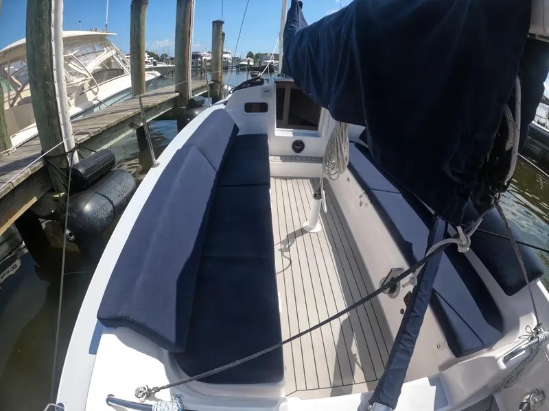 Slide: The Image of 2022 J Boats J/9 sailboat interior with blue seating at a marina. - 10