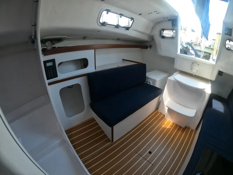 Slide: The Image of 2022 J Boats J/9 interior with seating, wooden flooring, and storage compartments. - 20
