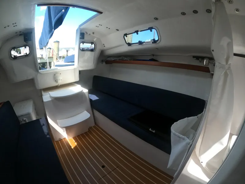 Slide: The Image of Interior of 2022 J Boats J/9 sailboat, featuring seating and wooden flooring. - 22