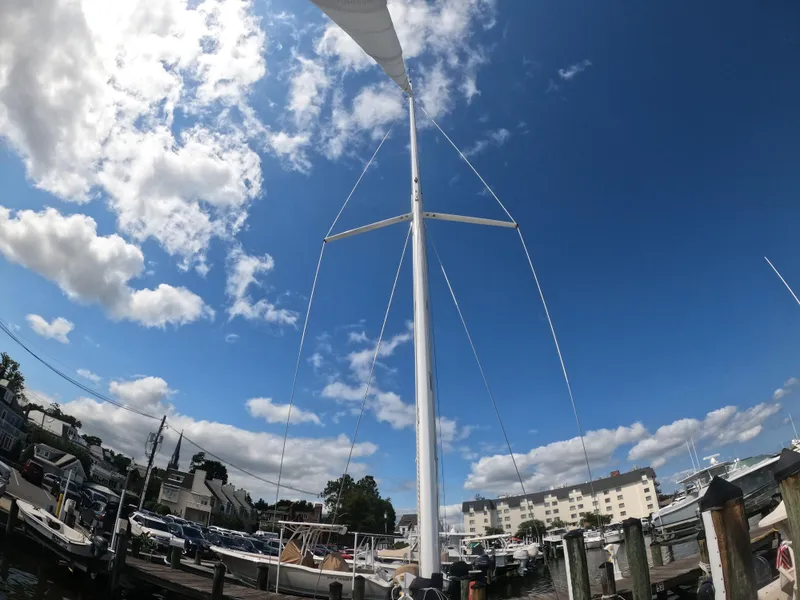 Slide: The Image of 2022 J Boats J/9 sailboat mast against a bright blue sky with clouds. - 25