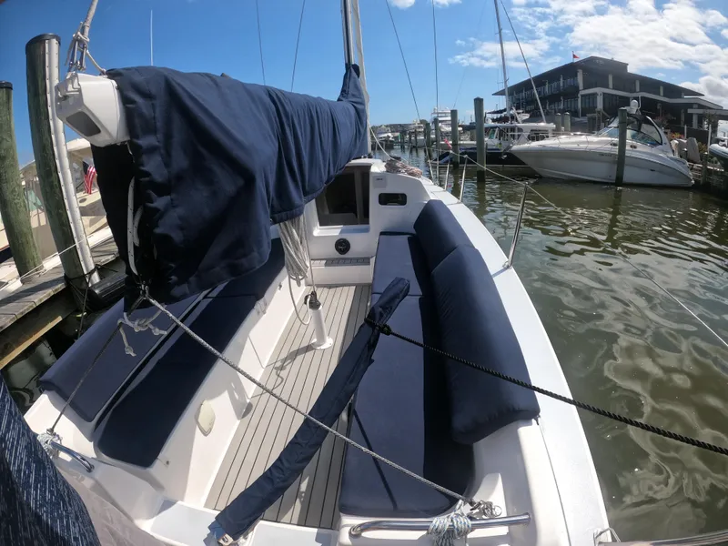 Slide: The Image of 2022 J Boats J/9 sailboat docked at marina, featuring blue covers and spacious seating. - 7