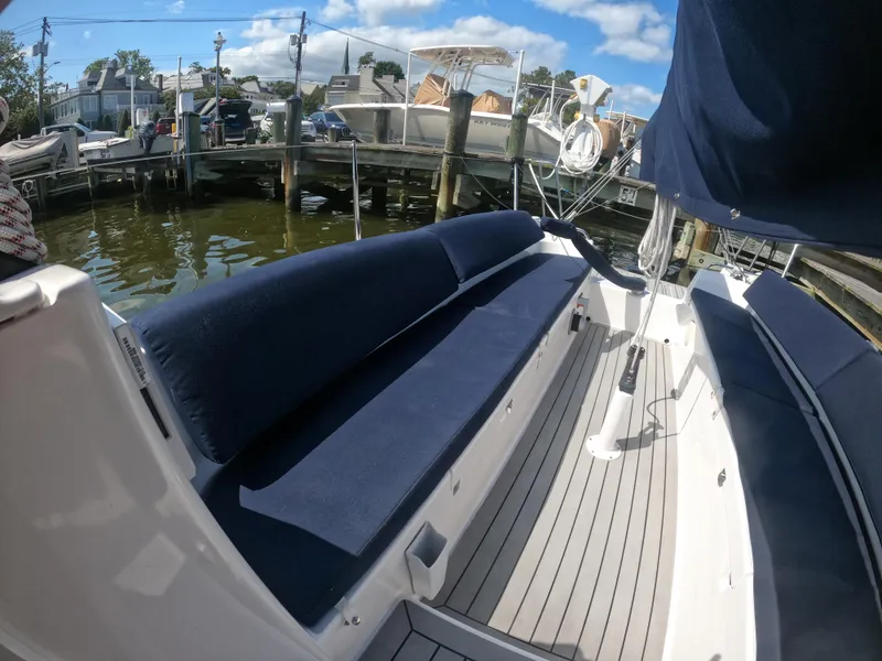 Slide: The Image of 2022 J Boats J/9 sailboat with blue seating, docked at a marina under a clear sky. - 9