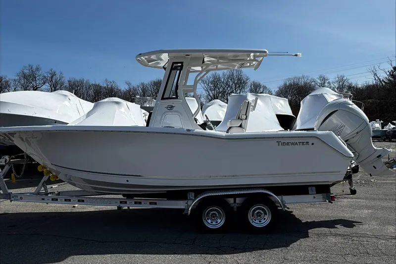 Slide: The Image of 2025 Tidewater 232 CC Adventure boat on trailer, parked outdoors. - 0