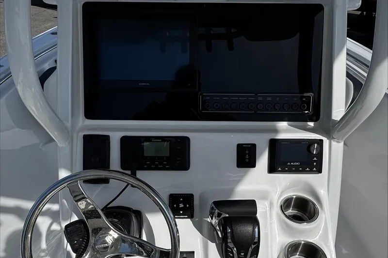 Slide: The Image of 2025 Tidewater 232 CC Adventure boat dashboard with steering wheel and electronic controls. - 17