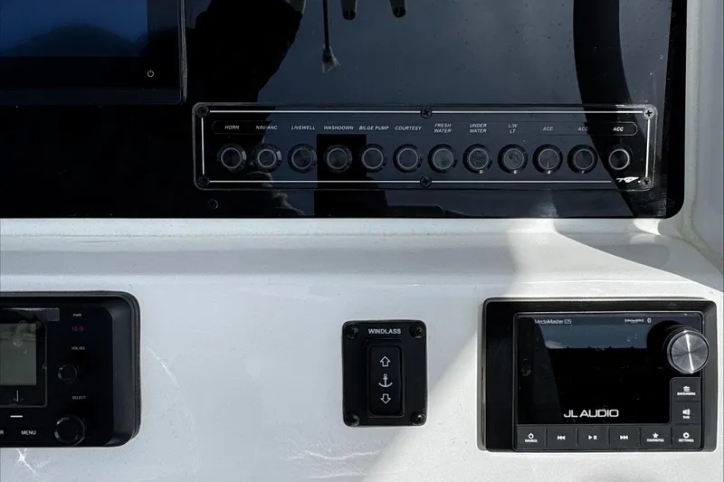 Slide: The Image of Control panel of 2025 Tidewater 232 CC Adventure boat with audio system and switches. - 19