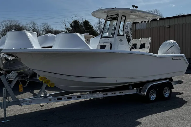 Slide: The Image of 2025 Tidewater 232 CC Adventure boat on trailer, parked outdoors. - 3