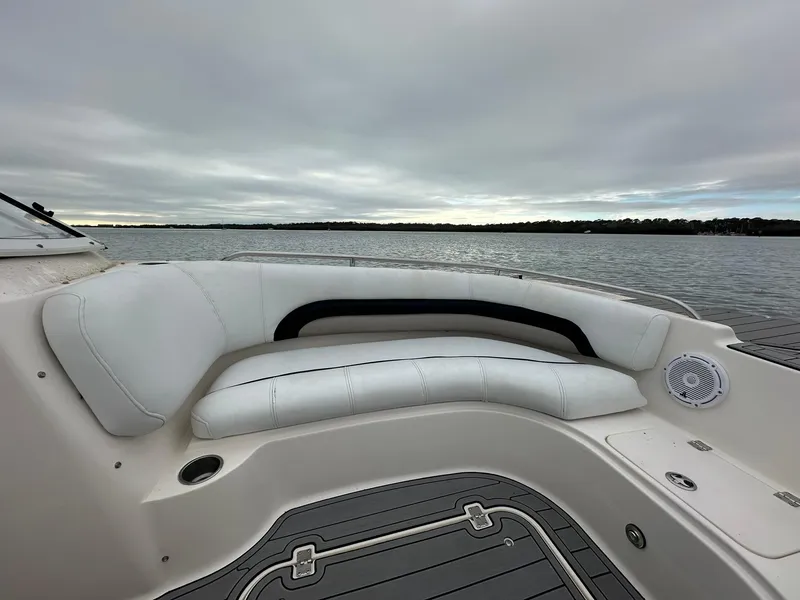 Slide: The Image of 2007 Hurricane SunDeck 237 OB boat interior with white seating, on a calm lake. - 4