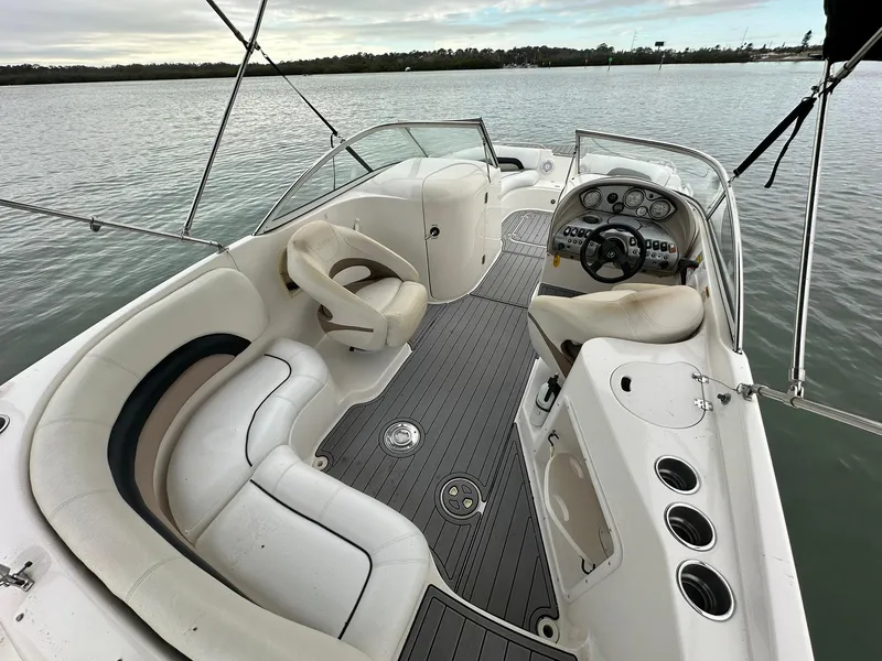 Slide: The Image of 2007 Hurricane SunDeck 237 OB boat interior with seating and steering wheel on calm water. - 5