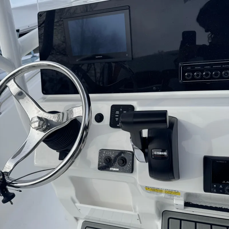 Slide: The Image of 2025 Tidewater 198 CC Adventure boat dashboard with steering wheel and controls. - 33