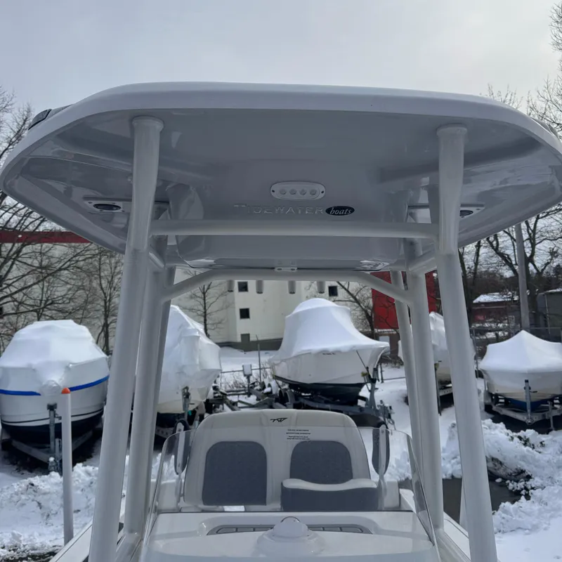 Slide: The Image of 2025 Tidewater 198 CC Adventure boat with T-top, parked in snowy marina. - 42