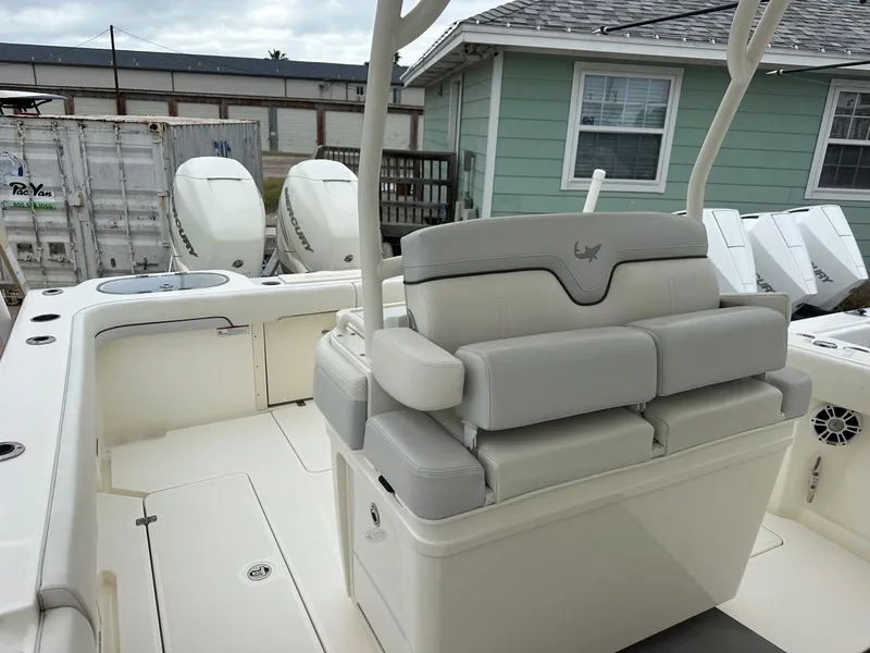 Slide: The Image of 2019 Mako 334 CC boat interior with cushioned seating and dual outboard motors. - 10
