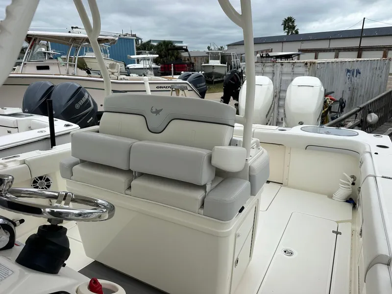 Slide: The Image of 2019 Mako 334 CC boat interior with cushioned seating and steering wheel. - 11