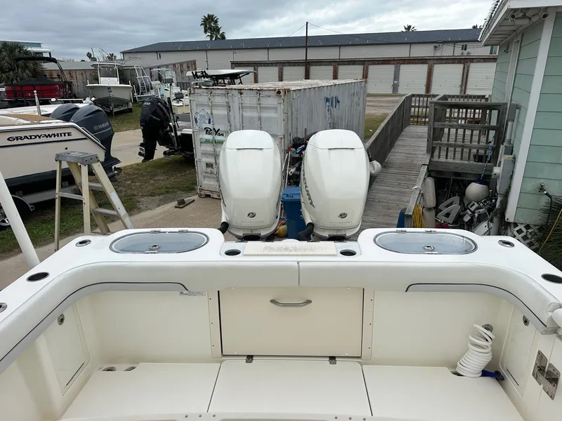 Slide: The Image of 2019 Mako 334 CC boat with dual outboard engines in a marina setting. - 12