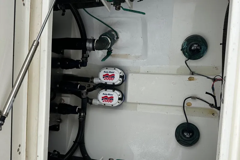 Slide: The Image of 2019 Mako 334 CC boat bilge area with pumps and wiring. - 14