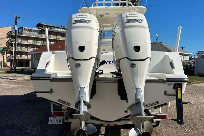 Slide: The Image of 2019 Mako 334 CC boat with twin 350 engines, parked outdoors. - 2