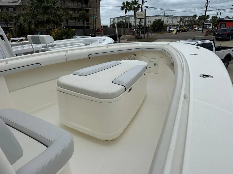 Slide: The Image of 2019 Mako 334 CC boat interior with cushioned seating and storage. - 6