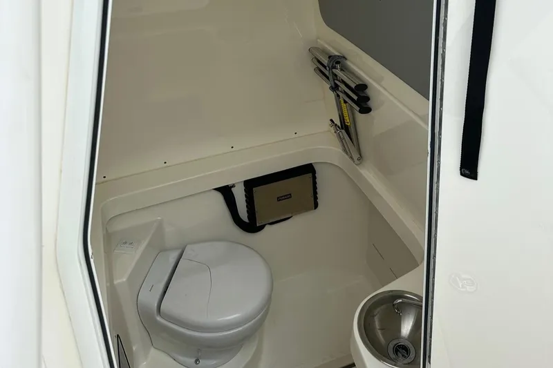 Slide: The Image of 2019 Mako 334 CC boat interior with compact toilet and sink. - 9