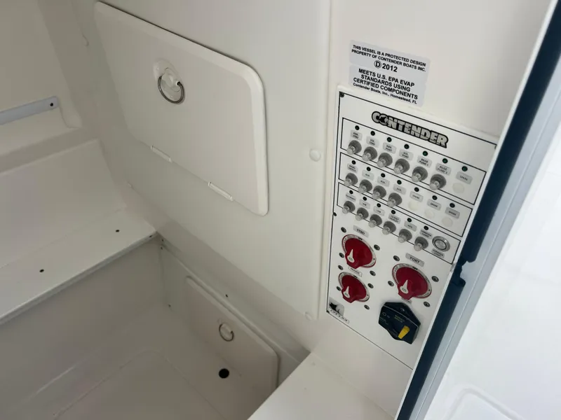 Slide: The Image of Control panel of 2023 Contender 30T boat, featuring switches and storage compartment. - 13